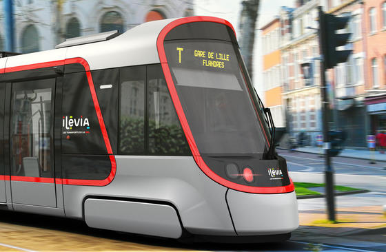 A Citadis tram bearing the logos of Ilevia is shown travelling from left to right along a tree-lined avenue. The train’s display screen shows its destination (Gare de Lille Flandres)