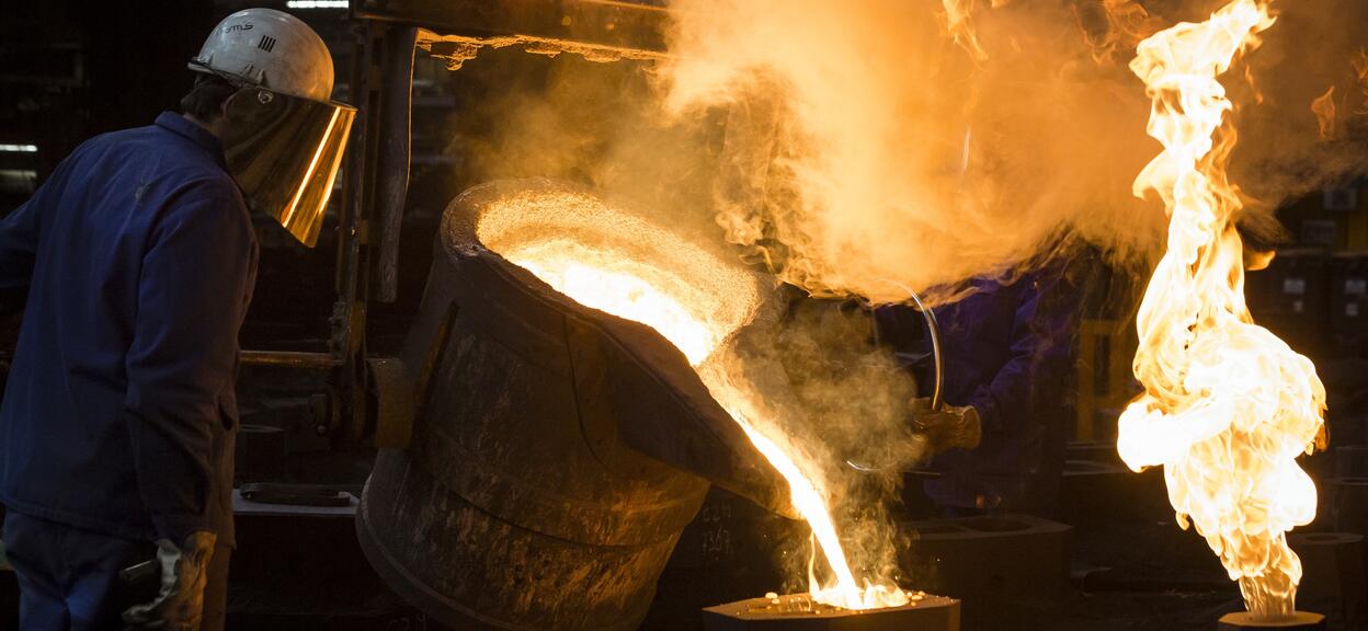 Casting ladle of liquid cast iron transferred into the sand mould
