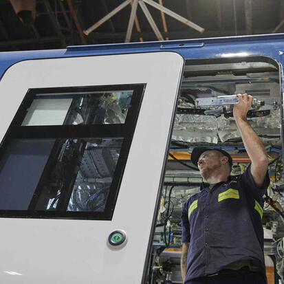 Employee installing a door on an Avelia Liberty passenger vehicle.