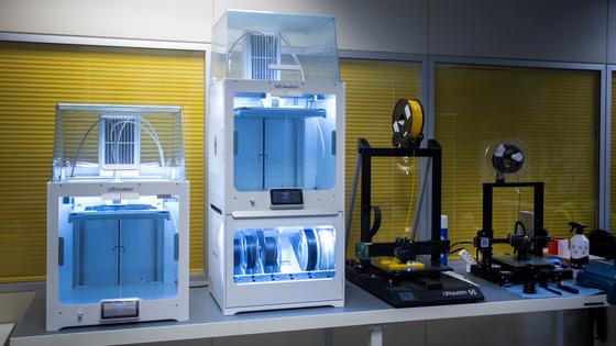 4 3D printing machines sitting on table