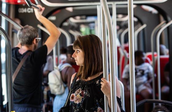 Passenger holding onto railway in tramway